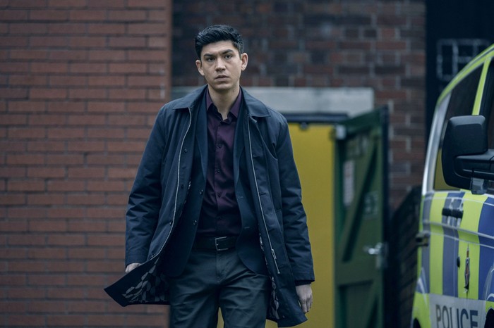 Archie Renaux as Hitch in The Jetty walking past a police car