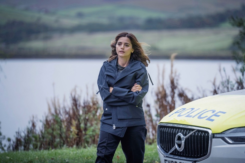 Jenna Coleman as Ember in The Jetty walking past a police car with arms folded