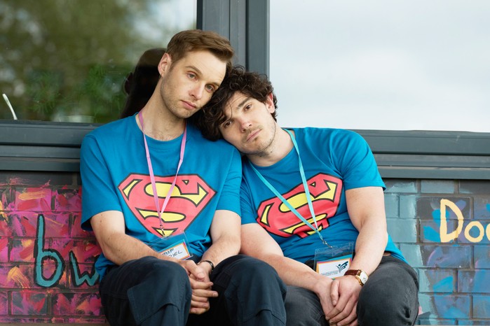 Gabriel and Andy wearing Superman t-shirts, sitting next to one another, with their heads leaning on one another