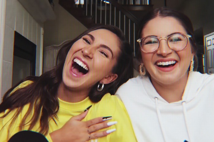 Melanie Wilking and Miranda Derrick. They are both smiling and laughing, looking ahead at the camera