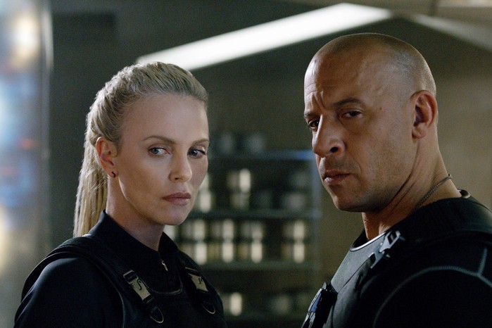 Vin Diesel as Dominic Toretto, Charlize Theron as Cipher in The Fate of the Furious standing together looking serious