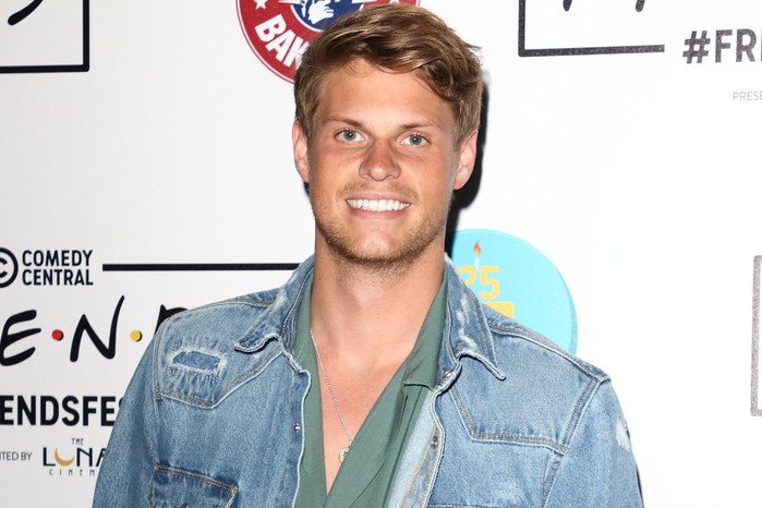 James Taylor arrives on the red carpet during the FriendsFest 2019 at Kennington Park in London. He is wearing a green shirt and blue denim overshirt.