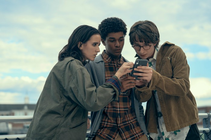 Abby Corrigan as Ema Winslow, Jaden Michael as Mickey Bolitar and Adrian Greensmith as Arthur "Spoon" Spindell) in Harlan Coben's Shelter looking at a phone.