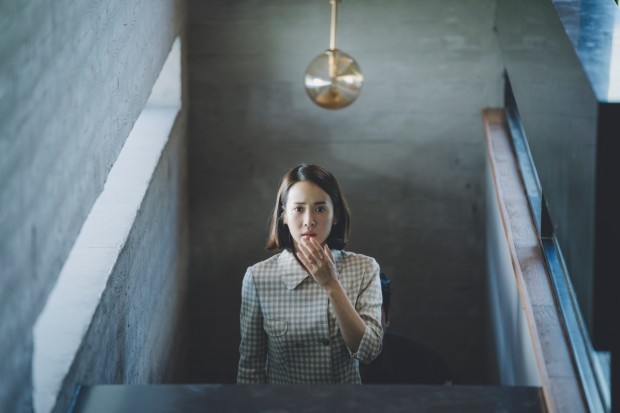 A woman on a staircase looking shocked