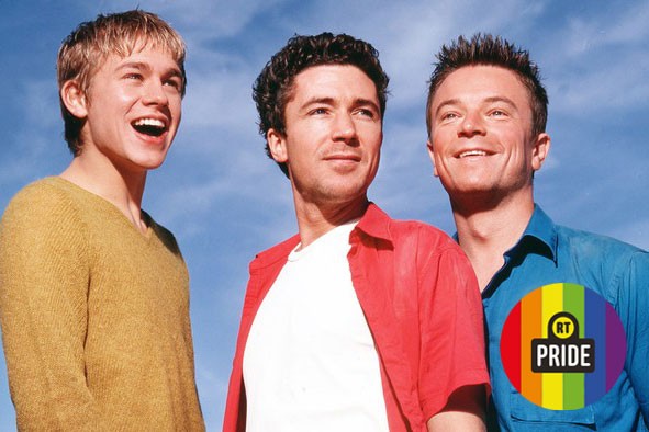 Charlie Hunham, Aiden Gillen, and Craig Kelly in Queer As Folk, with an RT Pride banner in the bottom right corner.