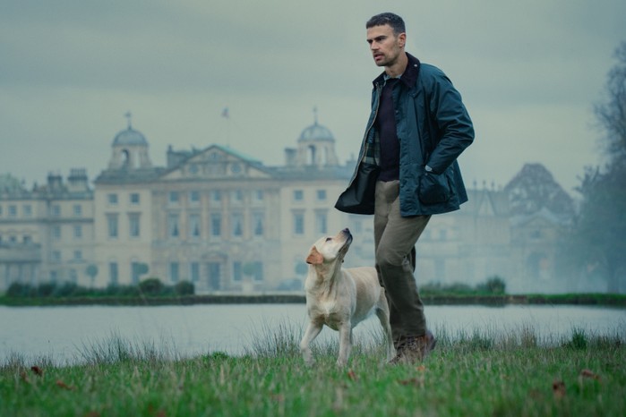 Theo James in The Gentlemen, walking with a dog on the grounds of a country house